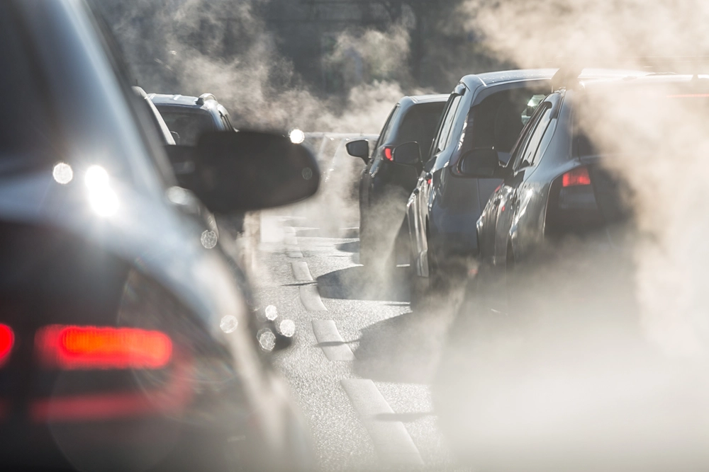 Fahrzeuge die von Dampf aus den Abgasleitungen umgeben sind