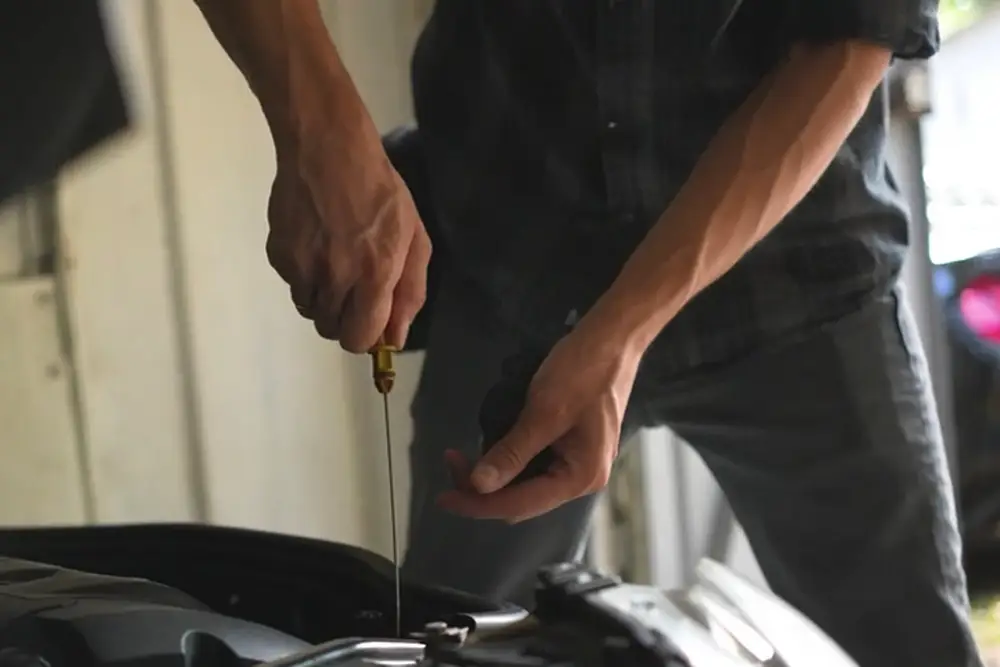 Ein Mechaniker ueberprueft den Oelstand